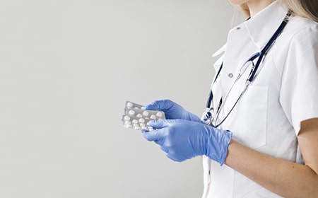 Enfermera con pastillas en la mano