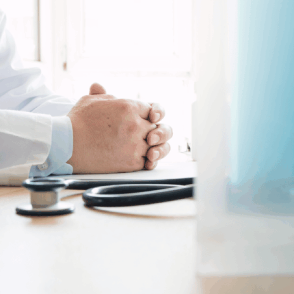 medico_apoya_manos_en_una_mesa